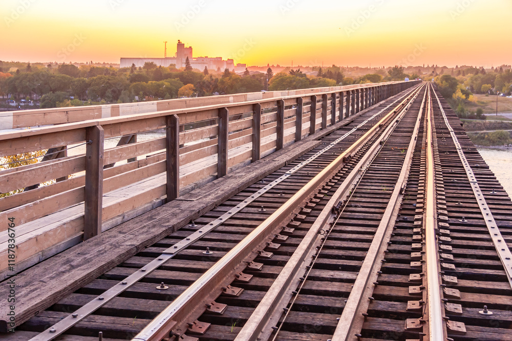 A train track with a bridge over a river A train track with a bridge over a river