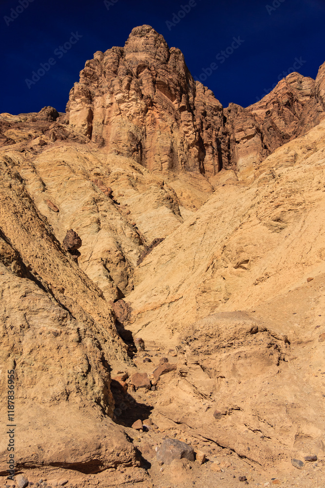 Fototapeta premium A rocky mountain with a blue sky in the background