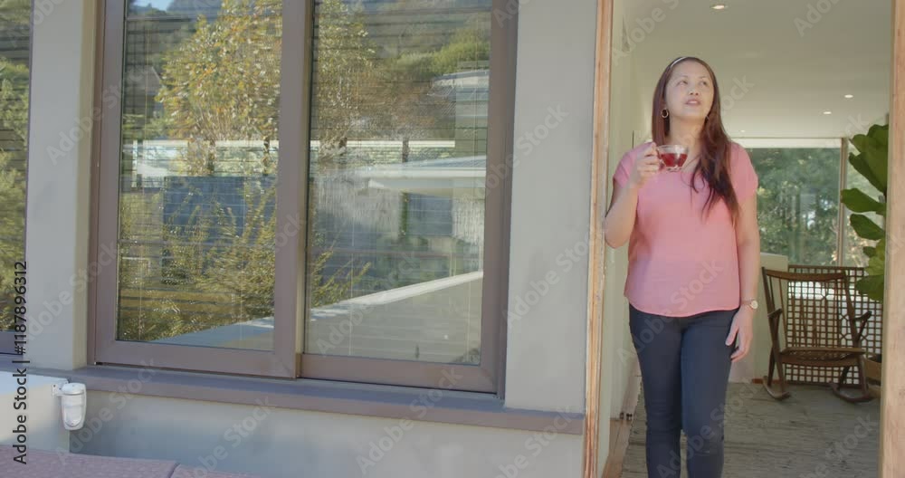 Standing outside, woman enjoying ice cream and looking into distance Standing outside, woman enjoying ice cream and looking into distance