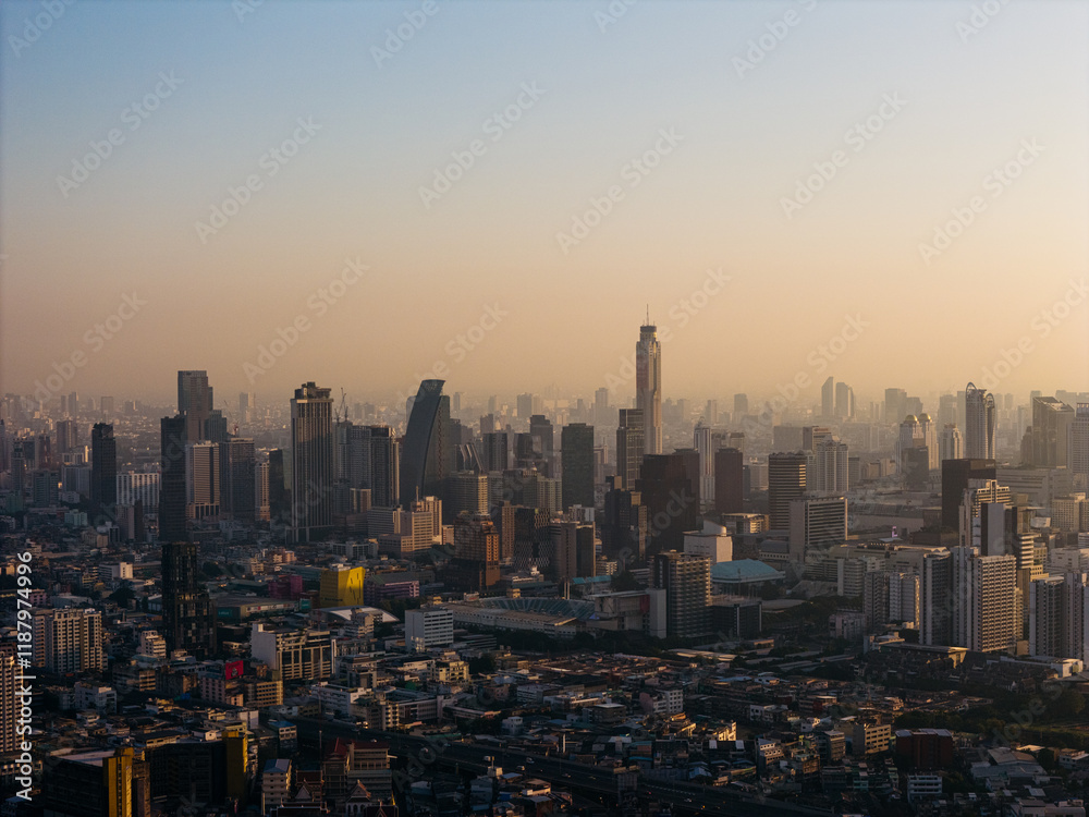 Fototapeta premium Bangkok high aerial panoramic view of Pathum Wan and Ratchathewi districts at sunset. A large asian capital city with skyscrapers and millions of inhabitants. High quality photo