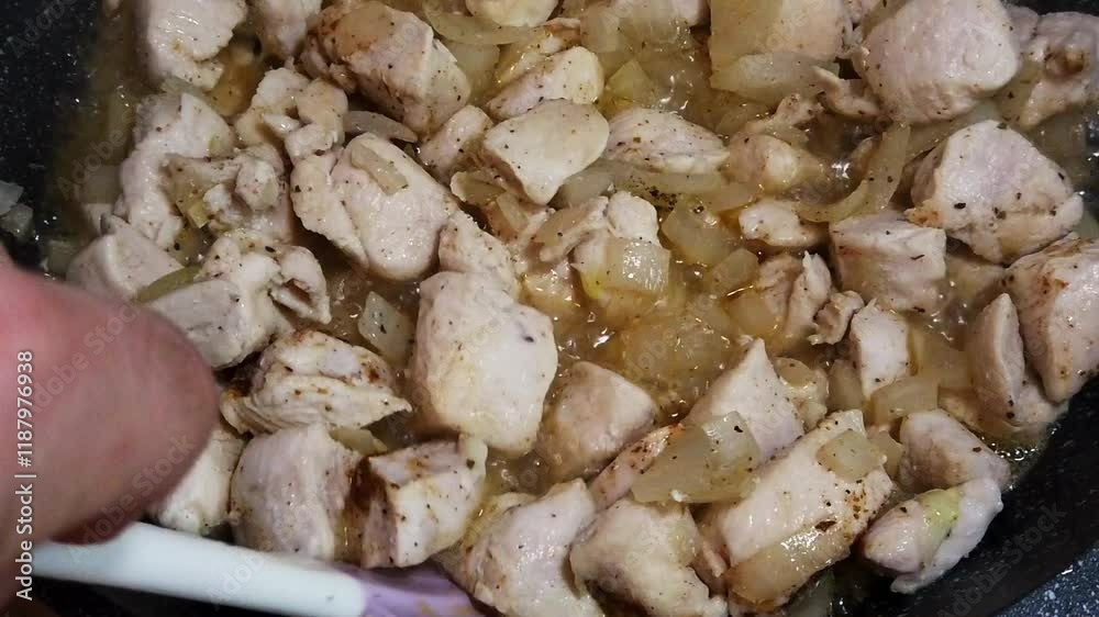 Sizzling turkey fillet cooked with onions in a hot skillet at home Sizzling turkey fillet cooked with onions in a hot skillet at home