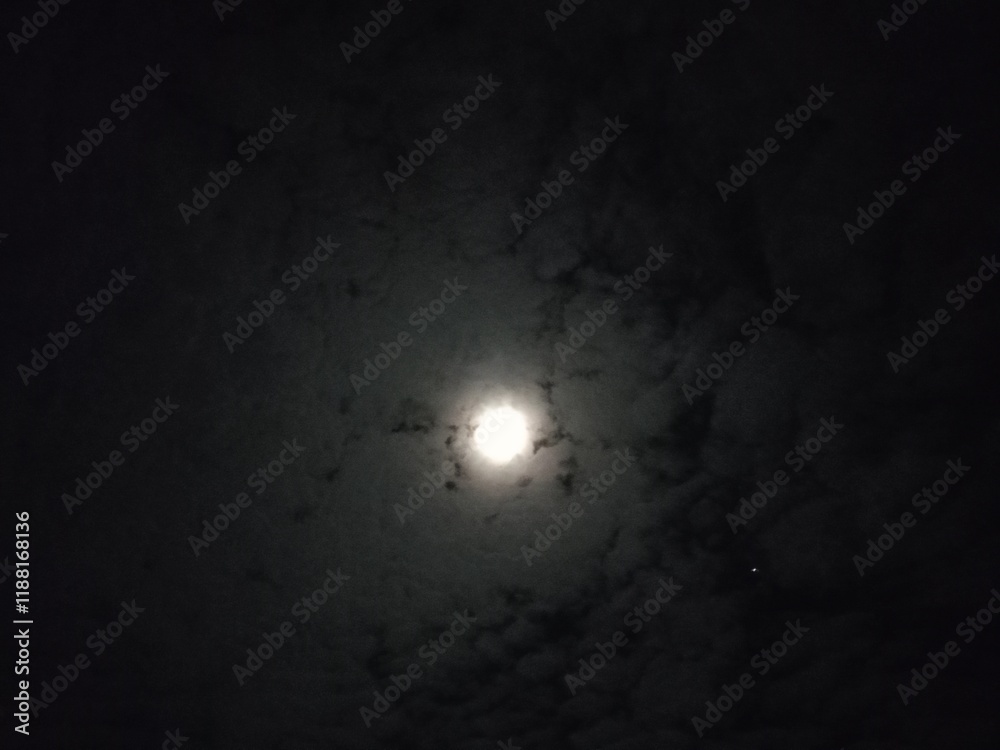 The moon was shining brightly covered by thin clouds The moon was shining brightly covered by thin clouds