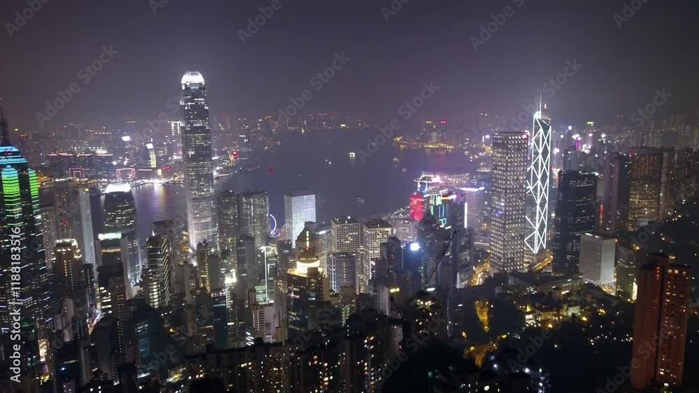 Aerial: The Vibrant Hong Kong Skyline And Harbor Sparkle At Night With Brightly Lit Skyscrapers, Ferries, And A Glowing Waterfront, Representing The City'S Dynamic Nightlife