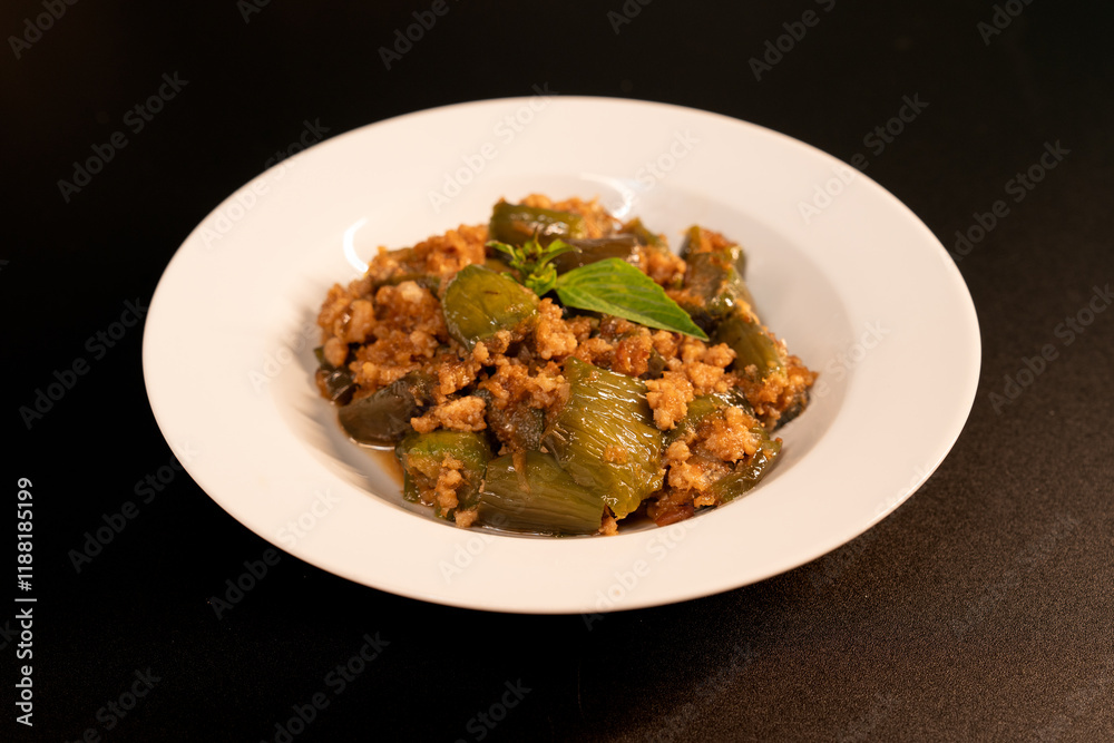 Stir-fried long eggplant (aubergine) with minced pork, on black background. Stir-fried long eggplant (aubergine) with minced pork, on black background.
