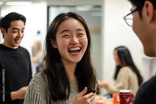 A group of young Asian entrepreneurs in an office, celebrating a milestone with excitement, smiling and exchanging congratulatory words. photo