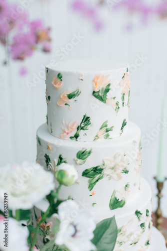 Three-tier floral wedding cake with buttercream decorations. photo