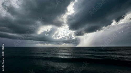 Dramatic ocean storm clouds rolling over dark waters with shimmering light