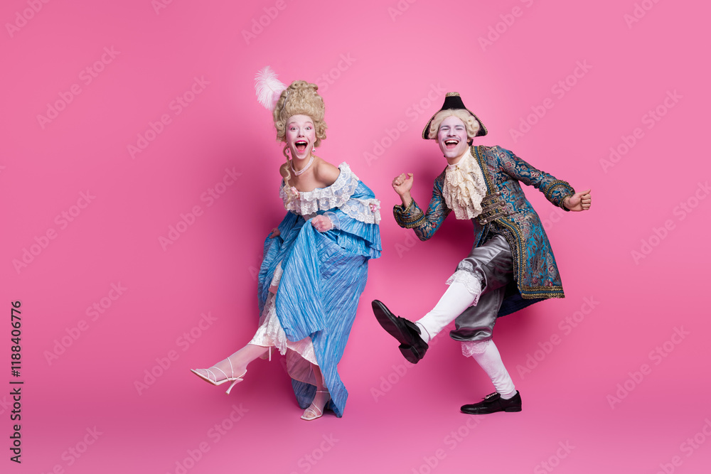 Two joyful people dressed in elegant period costumes, embodying a historical theme against a vibrant pink backdrop Two joyful people dressed in elegant period costumes, embodying a historical theme against a vibrant pink backdrop
