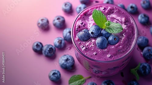 A vibrant blueberry smoothie topped with fresh blueberries and mint leaves.