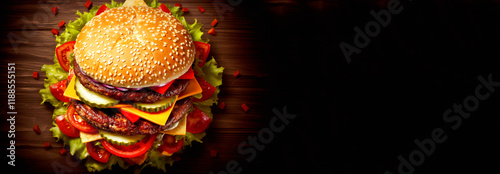 A top view of a delicious hamburger with fresh ingredients, placed on a bright, colorful background. Banner for design with copy space