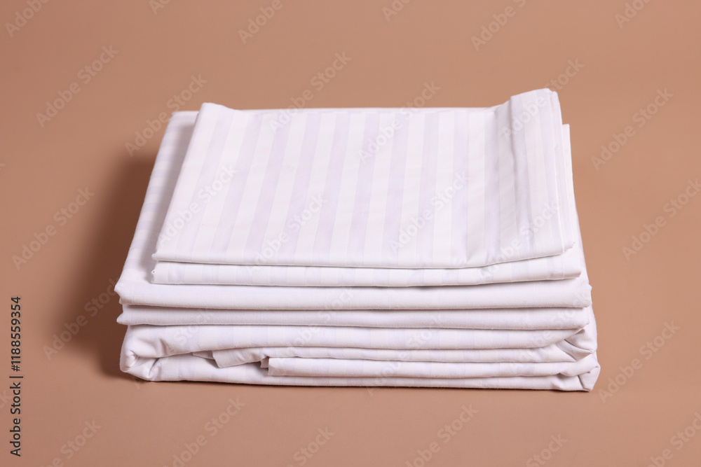 Stack of clean bed linens on beige background Stack of clean bed linens on beige background