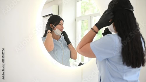 Cosmetologist Adjusting Protective Mask in Front of Mirror, Horizontal Frame