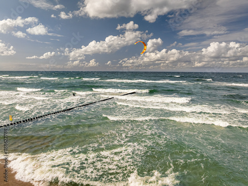 Kitesurfer riding the big waves at sea. Tourism in Poland.