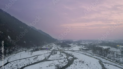 aerial drone pink sunset dusk shot passing over lidder river on the aru srinagar route with cars passing over roads and bridges showing the beauty of kashmir photo