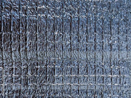 A texture of thermal insulated food packaging. Silver surface. Thick aluminum foil 