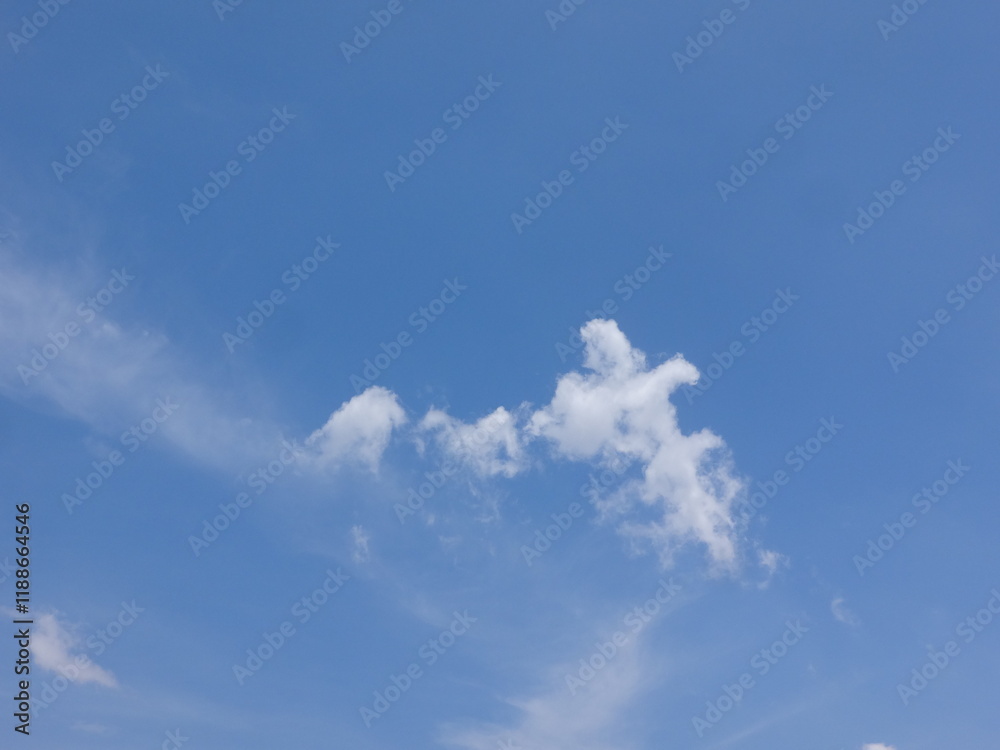 Clouds billow across the brilliant blue summer sky like cotton tufts, billowing, puffy, soft, the sky is bright blue and the clouds are white. The sky during the day has pure white clouds like cotton Clouds billow across the brilliant blue summer sky like cotton tufts, billowing, puffy, soft, the sky is bright blue and the clouds are white. The sky during the day has pure white clouds like cotton