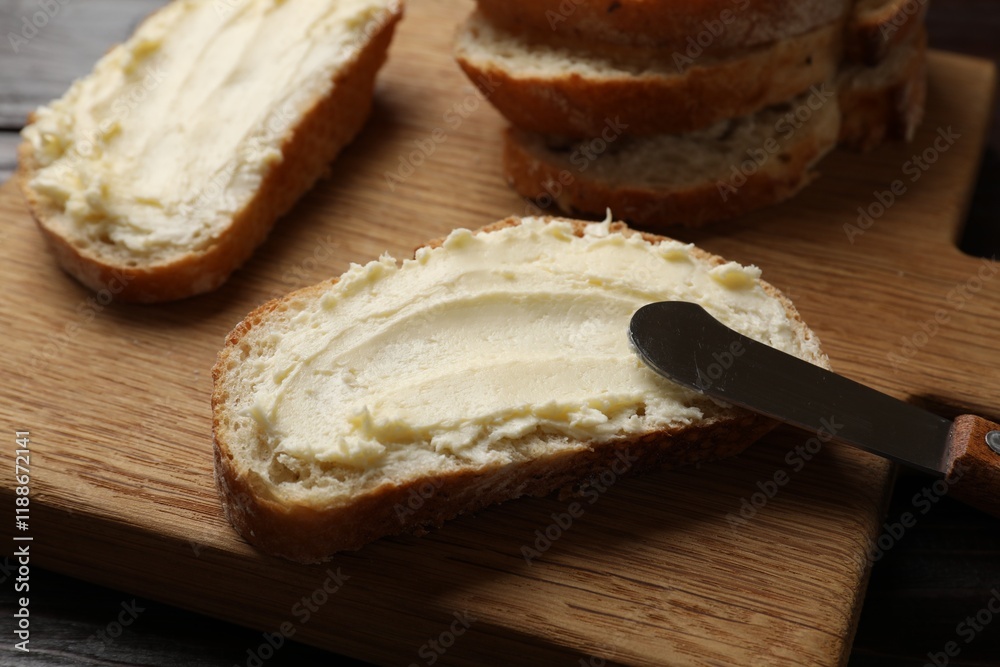 Fresh bread with butter and knife on wooden board, closeup Fresh bread with butter and knife on wooden board, closeup