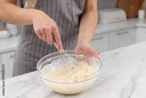 Tableau sur toile Woman making dough at white marble table indoors, closeup