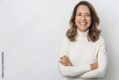 Middle-aged woman, warm smile, white turtleneck sweater, arms crossed, confident pose, studio lighting, neutral background, professional headshot, natural makeup, highlighted brown hair, friendly expr