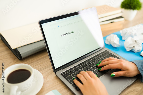 Tableau sur toile Female author typing chapter one of her new novel on laptop at home office desk