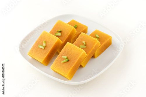 Mysore pak, a traditional, popular, and delicious sweet dish native to the city of Mysore, Karnataka, India, is made from ingredients like gram flour, ghee and sugar, on a ceramic plate.