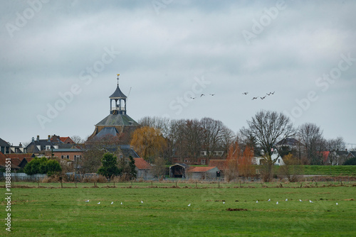 Historic charm of dorp hoge zwaluwe showcasing the iconic church and serene rural landscape under a cloudy sky photo