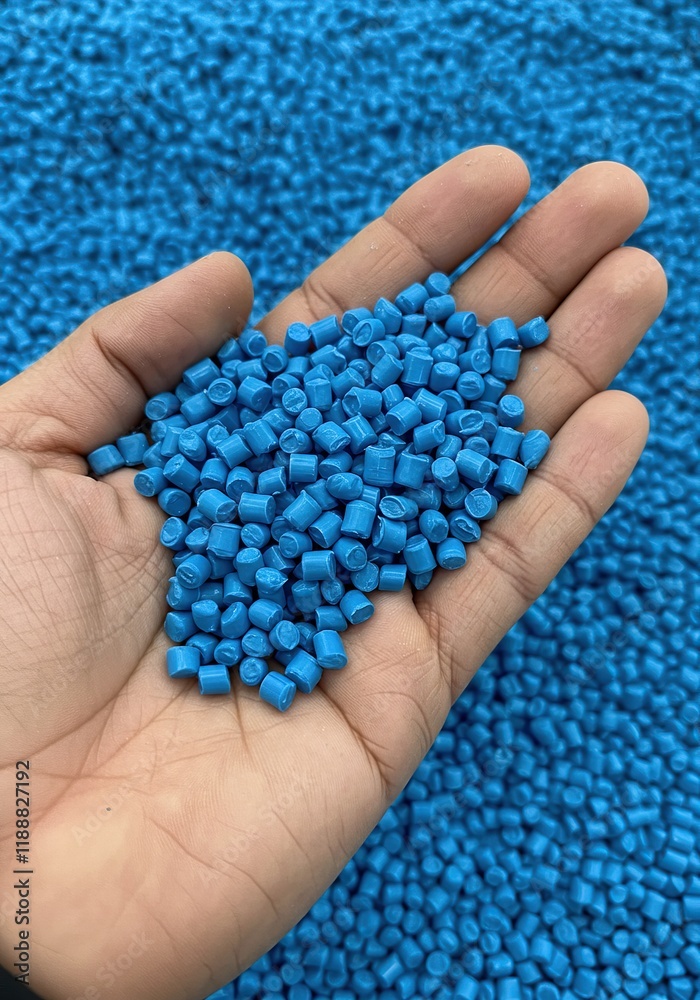 Handful of Blue Plastic Pellets. This image can be used in various contexts, such as illustrating industrial processes, material science, or the concept of recycling.
