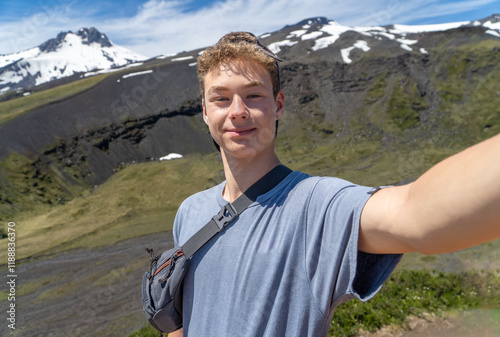selfie of a young teen in the top of a mountain during a beautiful summer day