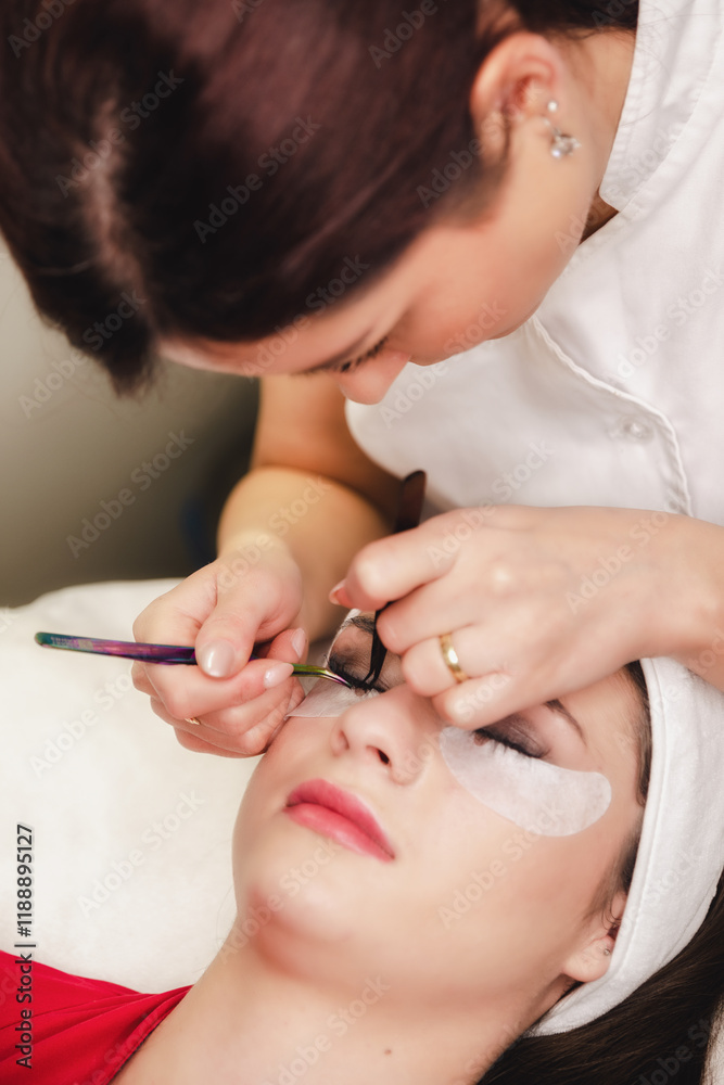 Beautician making eyelash extension procedure in beauty salon. Permanent eylashes make up