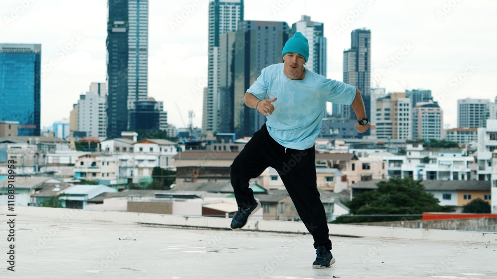 Skilled caucasian B-boy dancer practicing street dancing at rooftop with city sites or urban. Motion shot of young man performing street dance by doing freeze pose. Outdoor sport 2024. Hiphop. Skilled caucasian B-boy dancer practicing street dancing at rooftop with city sites or urban. Motion shot of young man performing street dance by doing freeze pose. Outdoor sport 2024. Hiphop.