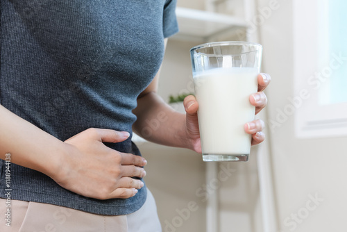 lactose intolerance concept. Woman pushing glass of milk deny to drink. photo