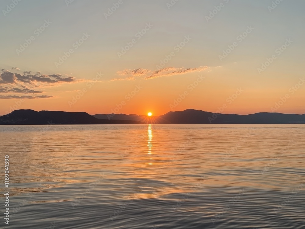 sunset over calm water with silhouetted mountains in the distance sunset over calm water with silhouetted mountains in the distance