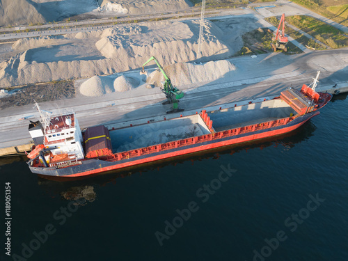 Drone view: a bulk carrier takes on tons of crushed stone at the port of Muuga. The large-scale loading demonstrates the Estonian port's activity. photo