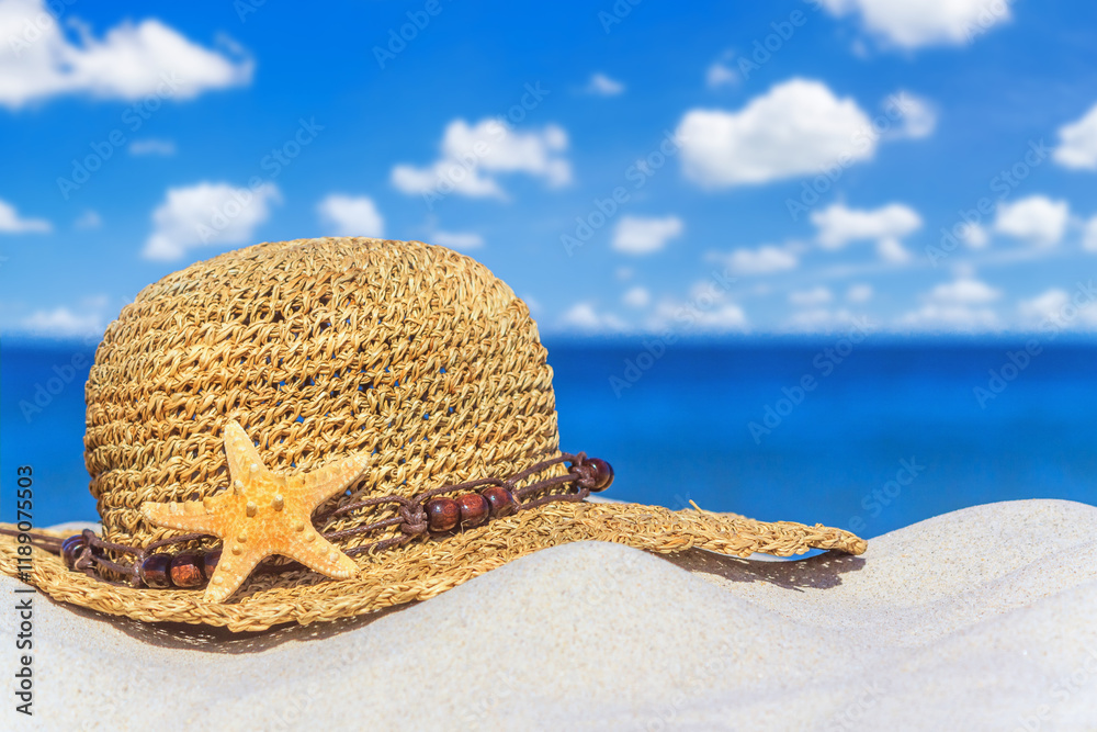 Close-up view of a sun hat on a sandy beach by the sea, selective focus. Beach holiday concept, background with copy space for text