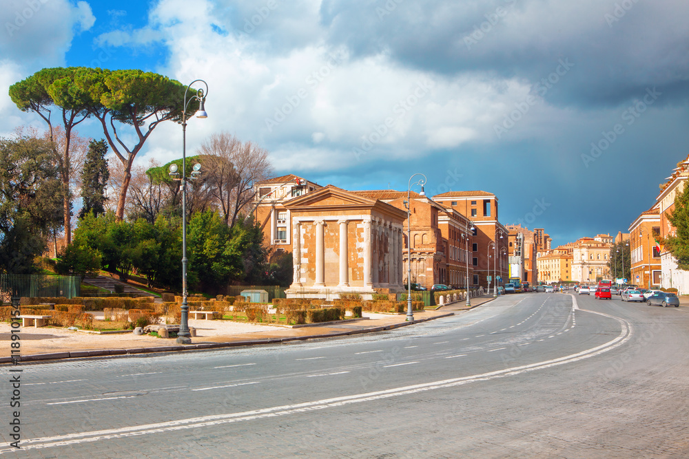 Street in Rome highlighting classical architecture with a prominent building featuring columns and a pediment, reminiscent of ancient Roman design. Ancient and modern elements alongside the street