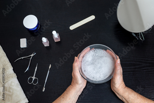 Elderly woman 70+ years old doing her own manicure at home, Self-care theme, beauty and self-care, self-love, independence and aging with grace. Top view photo