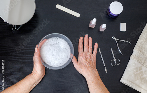 Elderly woman 70+ years old doing her own manicure at home, Self-care theme, beauty and self-care, self-love, independence and aging with grace. Top view photo