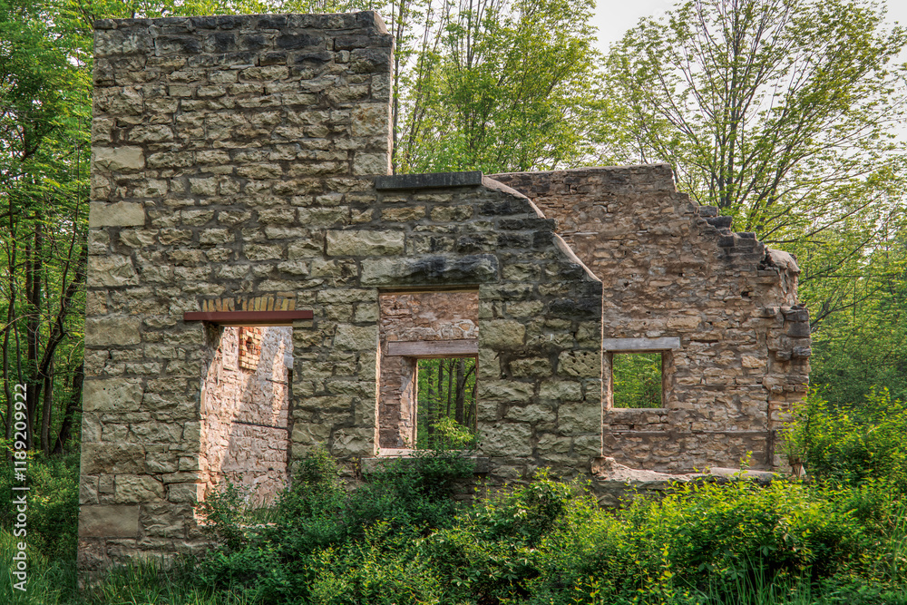 The stone ruins of a rural 1800s 2-storey estate house, in the countryside surround by woods and overgrown grass. The stone ruins of a rural 1800s 2-storey estate house, in the countryside surround by woods and overgrown grass.
