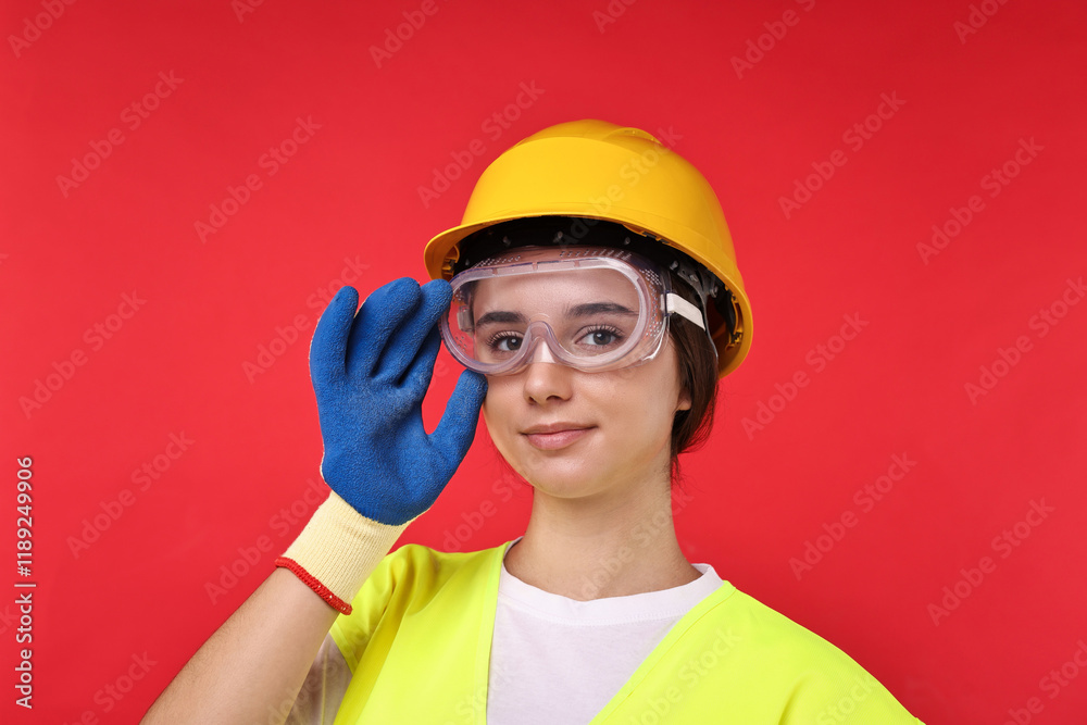 Girl with safety equipment on red background. Work for teenagers