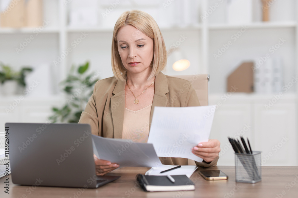Middle aged woman working at table in office Middle aged woman working at table in office