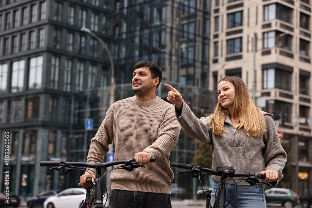 Beautiful happy couple with bicycles spending time together outdoors