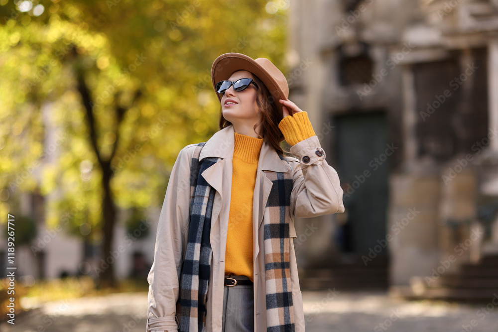 Fototapeta premium Charming young woman in stylish outfit on city street. Autumn season