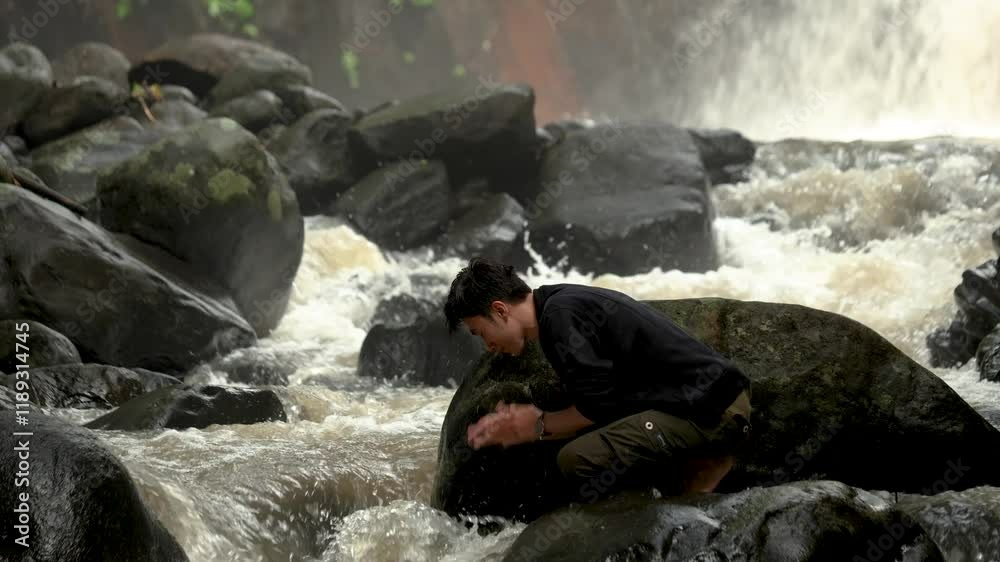 man washing his face in the wild. man alone in the wild and looking alone