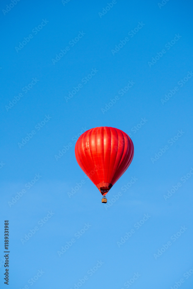 Flying red hot air balloon in the blue sky Flying red hot air balloon in the blue sky
