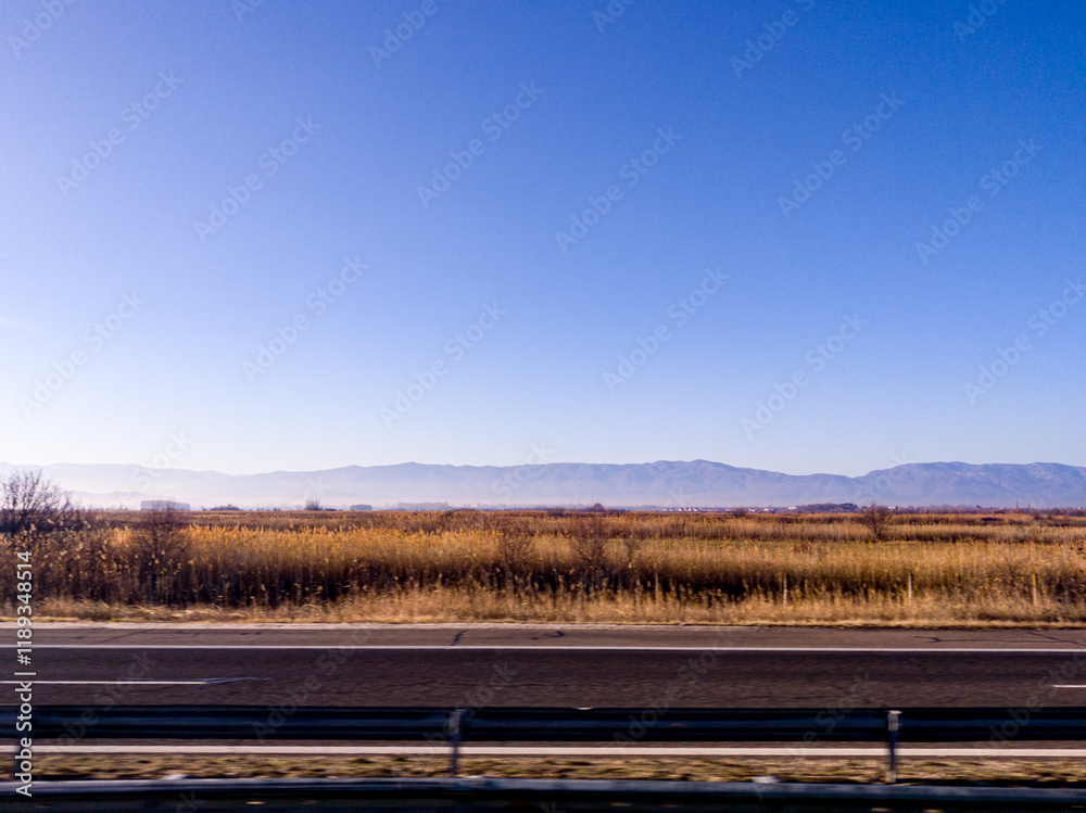 View to field and mountain from highway