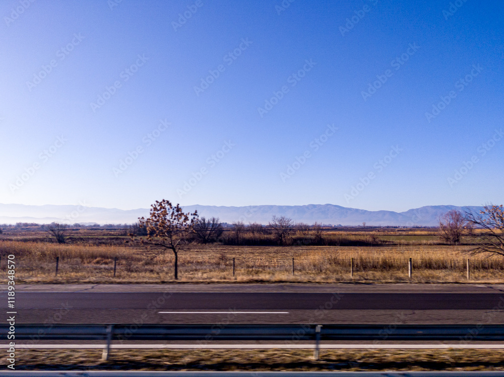 View to field and mountain from highway