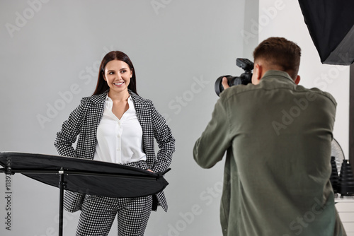 Photographer working with model in professional photo studio