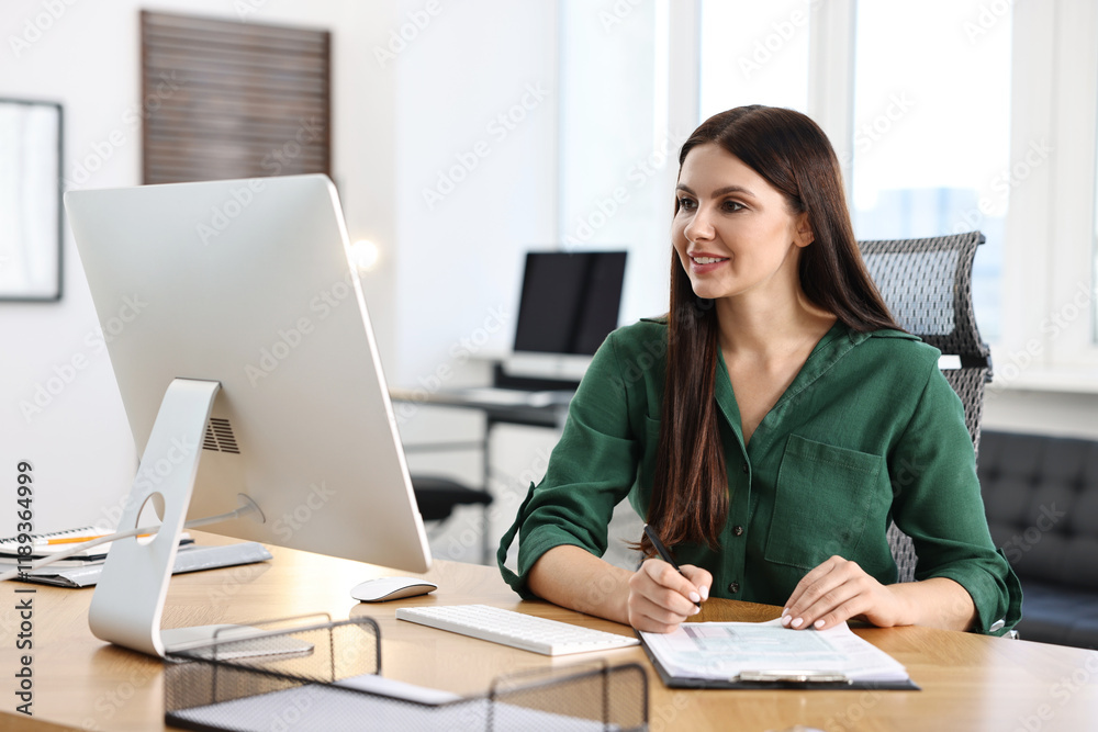 Woman working with document at table in office Woman working with document at table in office