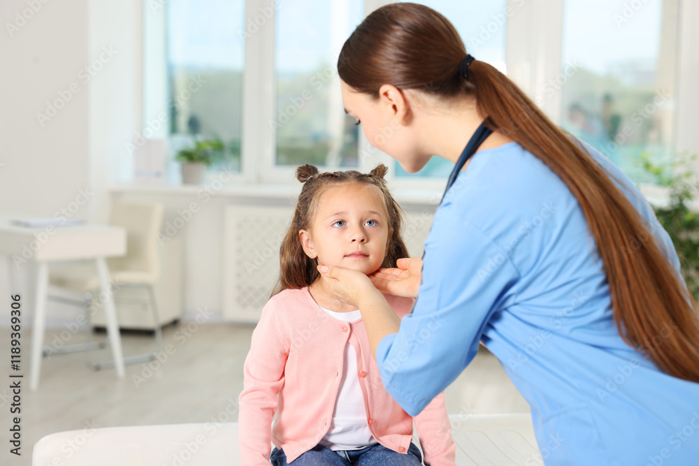 Doctor examining girl's throat in clinic during appointment Doctor examining girl's throat in clinic during appointment