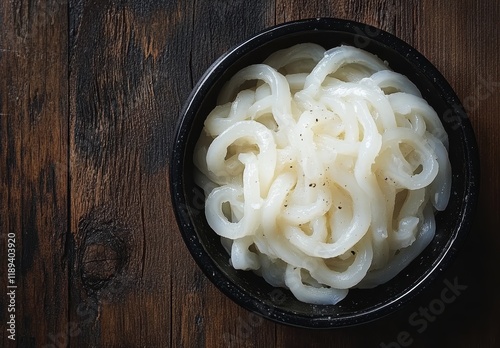 自家製のつるつるしたうどんが黒い器に盛られている様子 photo